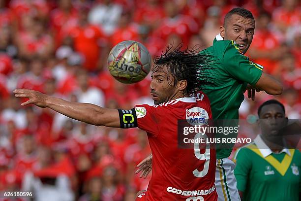 America de Cali's Ernesto Farias vies for the ball with Deportes Quindio's Jeider Riquett during a Colombian Professional Football tournament...