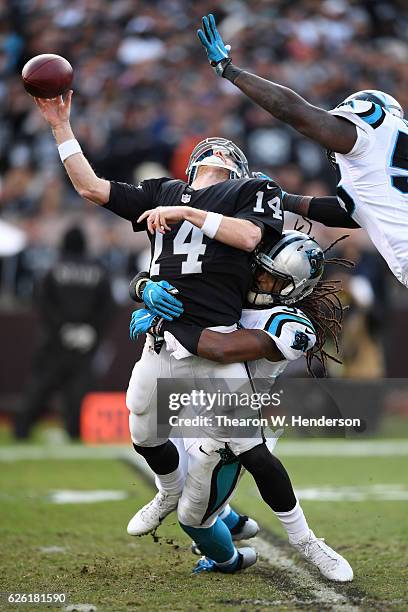 Matt McGloin of the Oakland Raiders is hit by Tre Boston of the Carolina Panthers during their NFL game on November 27, 2016 in Oakland, California.