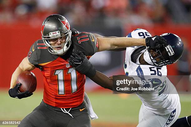 Adam Humphries of the Tampa Bay Buccaneers tries to break away from Cliff Avril of the Seattle Seahawks in the fourth quarter of the game at Raymond...