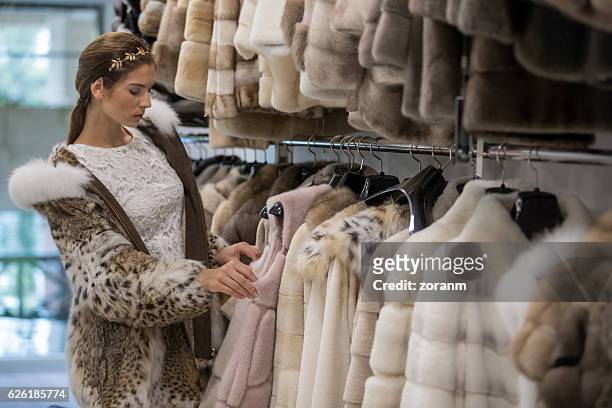 schaufenstereinkauf im schaufenster - woman in fur coat stock-fotos und bilder