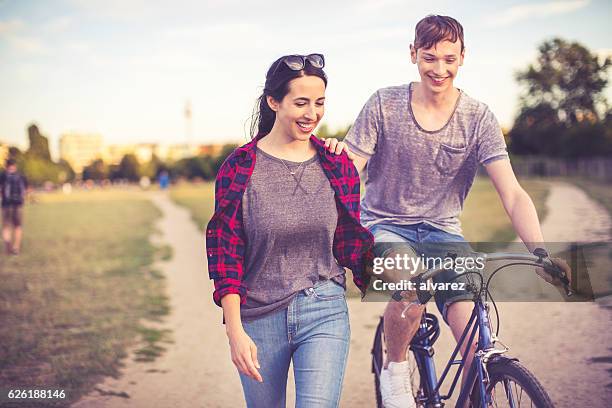 couple in love riding through a berlin public park - berlin diversity alexanderplatz stockfoto's en -beelden