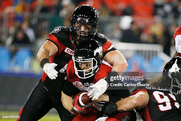 Ottawa Redblacks Arnaud Gascon-Nadon tackles Calgary's quarterback, Bo Levi Mitchell during the first half of CFL action as the Calgary Stampeders...