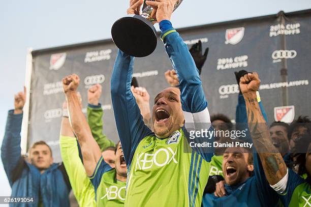 Osvaldo Alonso of Seattle Sounders hoists the Western Conference trophy after the team defeated the Colorado Rapids during the second leg of the...
