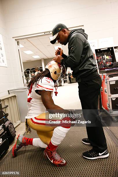 DuJuan Harris of the San Francisco 49ers gets air put into his helmet by Assistant Equipment Manager Robert Lloyd in the locker room prior to the...