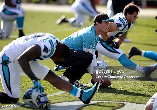 Carolina Panthers linebacker Luke Kuechly, center, crouches between linebackers Thomas Davis, left and A.J. Klein, right, during stretching on...