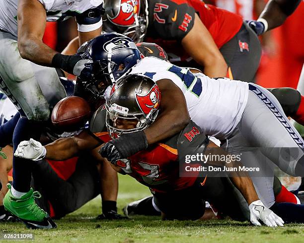 Defensive End Cliff Avril of the Seattle Seahawks strips the ball loose from Running back Doug Martin of the Tampa Bay Buccaneers during the game at...
