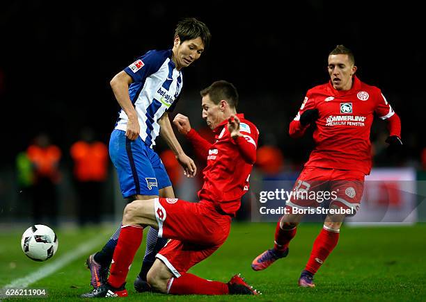 Genki Haraguchi of Hertha BSC is challenged by Gaetan Bussmann of 1. FSV Mainz 05 during the Bundesliga match between Hertha BSC and 1. FSV Mainz 05...