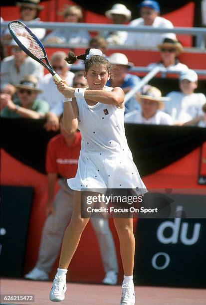 Monica Seles of Yugoslavia hits a return during a women's singles match at the Du Maurier Canadian Open circa 1995 at the Jarry Stadium in Montreal,...