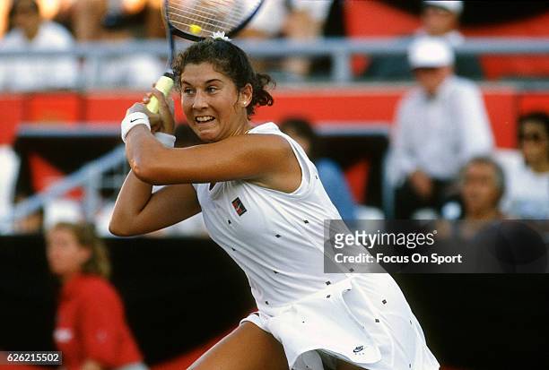 Monica Seles of Yugoslavia hits a return during a women's singles match at the Du Maurier Canadian Open circa 1995 at the Jarry Stadium in Montreal,...