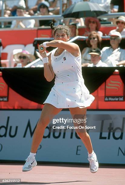 Monica Seles of Yugoslavia hits a return during a women's singles match at the Du Maurier Canadian Open circa 1995 at the Jarry Stadium in Montreal,...