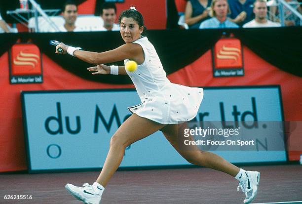Monica Seles of Yugoslavia hits a return during a women's singles match at the Du Maurier Canadian Open circa 1995 at the Jarry Stadium in Montreal,...