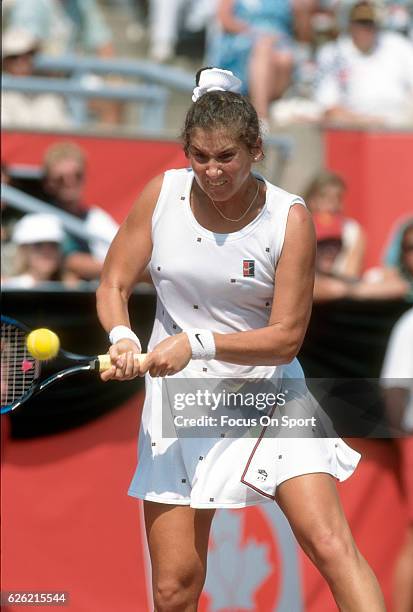 Monica Seles of Yugoslavia hits a return during a women's singles match at the Du Maurier Canadian Open circa 1995 at the Jarry Stadium in Montreal,...