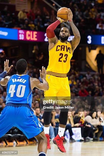 LeBron James of the Cleveland Cavaliers shoots over Harrison Barnes of the Dallas Mavericks during the second half at Quicken Loans Arena on November...