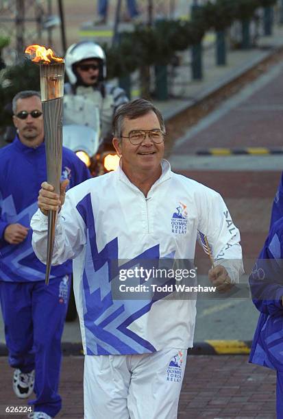 Billy Payne runs with the Olympic Torch at the beginning of the 2002 Salt Lake Olympic Torch Relay in Centenial Park in Atlanta, Georgia. DIGITAL...