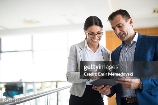 Two business people discussing business strategy using digital tablet Two business people discussing business strategy using digital tablet