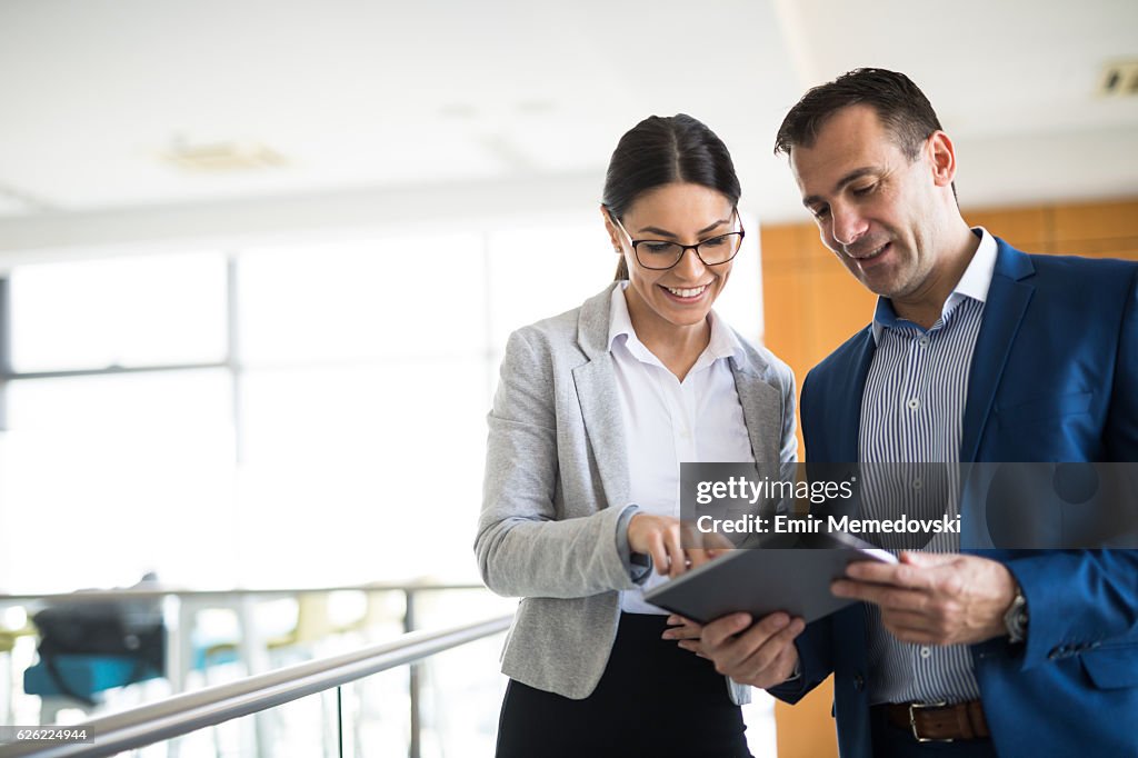 Two business people discussing business strategy using digital tablet