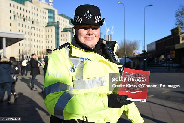 Constable Smith holds a flyer in front of the Secret Intelligence Service building, the headquarters of MI6, at Vauxhall Bus station in south London,...