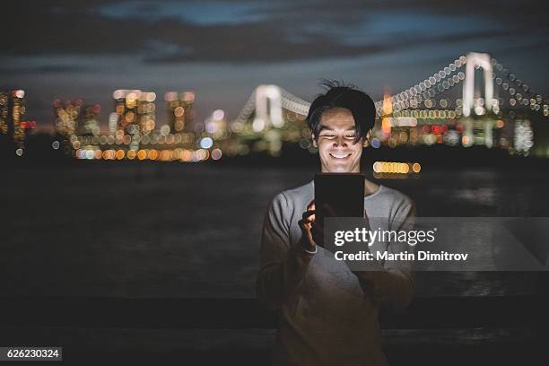 man in tokyo using tablet pc - namoro pela internet imagens e fotografias de stock