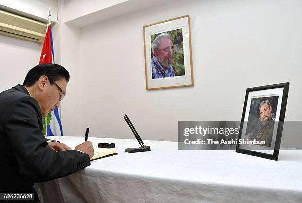 Ruling Liberal Democratic Party Election Bureau chief Keiji Furuya signs in the condolence book at Cuban Embassy on November 27, 2016 in Tokyo,...