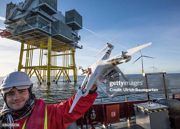 Wind turbines in the offshore wind farm Amrumbank West of the E.ON SE and a photo drone. In the background a substation.