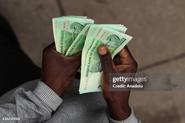 Man counts new banknotes as Zimbabwe Central bank launches new banknotes due to economical crisis in the country and decreasing of cash stores, in...