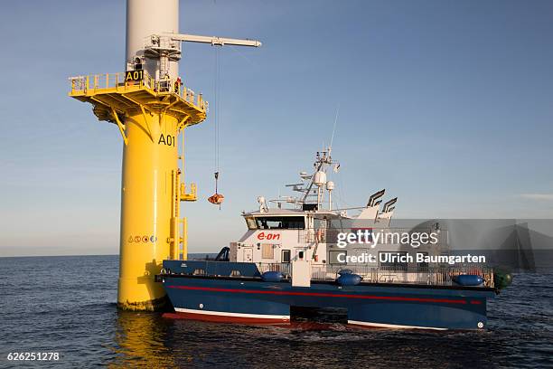 Wind turbines in the offshore wind farm Amrumbank West of the E.ON SE. Technicians during maintenance work on a wind turbine and a supply vessel.