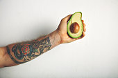 Man's arm with half of avocado