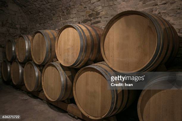 stacked wine casks in warehouse - san gimignano stockfoto's en -beelden
