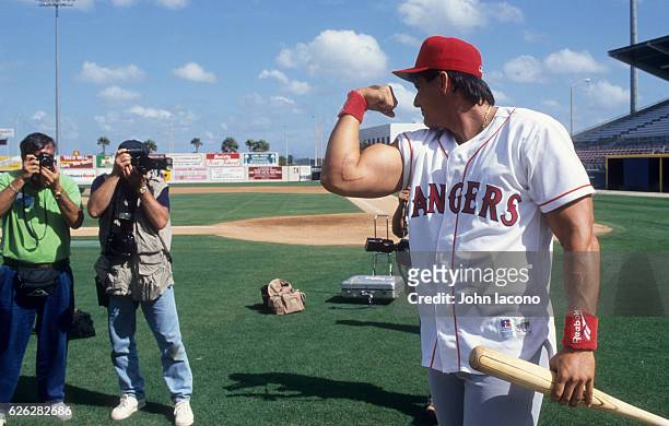 Texas Rangers Jose Canseco flexing his bicep showing is scar during spring training at Charlotte Sports Park. Scar is due to Tommy John elbow...