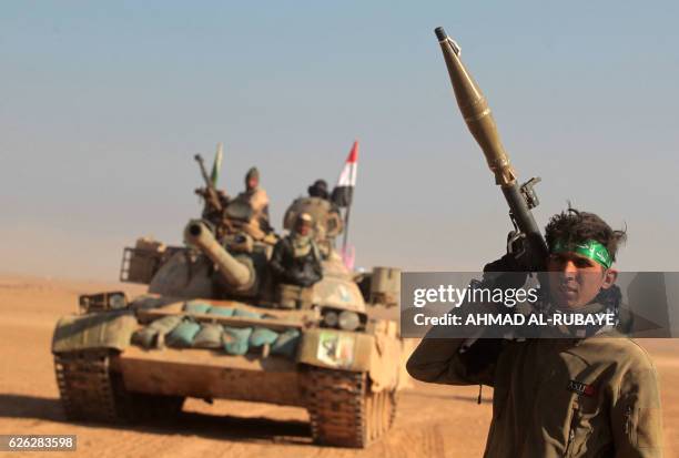 Iraqi Shiite fighters from the Hashed al-Shaabi paramilitaries advance in a desert area near the village of Tall Abtah, southwest of Mosul, on...