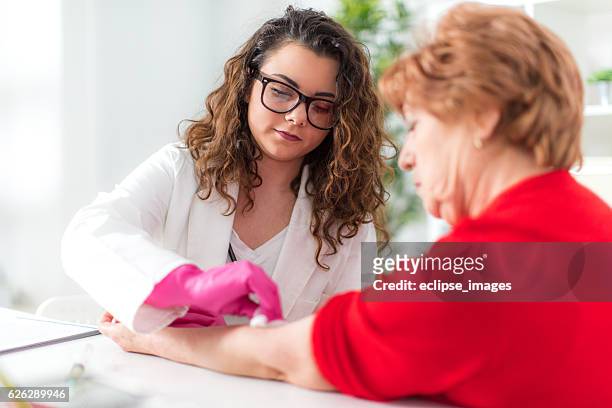 nurse giving injection to senior woman - two shot stock pictures, royalty-free photos & images