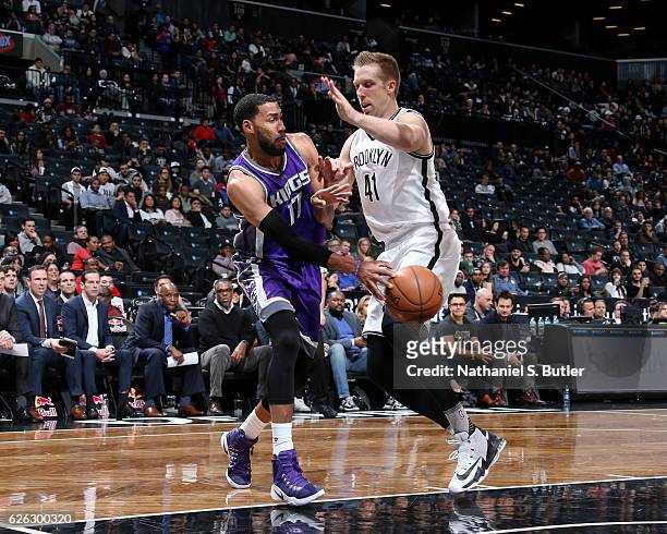 Garrett Temple of the Sacramento Kings passes the ball around Justin Hamilton of the Brooklyn Nets on November 27, 2016 at Barclays Center in...