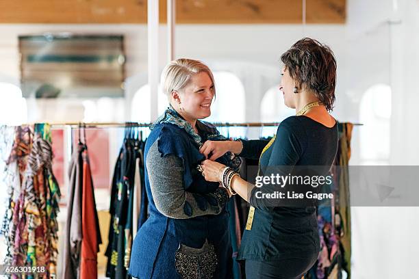 fashion designer  taking customer measurement in clothing boutique - lise gagne stock pictures, royalty-free photos & images