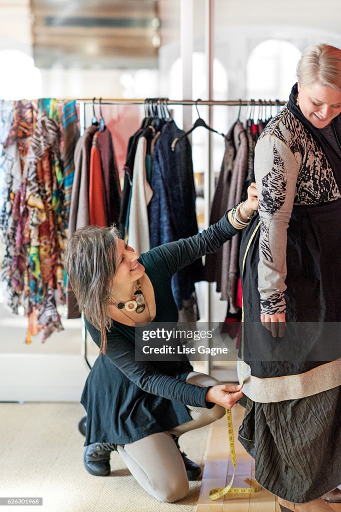 Fashion designer  taking customer measurement in clothing boutique