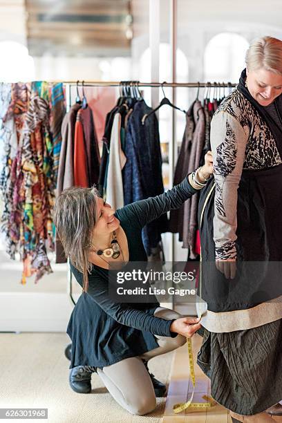 fashion designer  taking customer measurement in clothing boutique - lise gagne stock pictures, royalty-free photos & images
