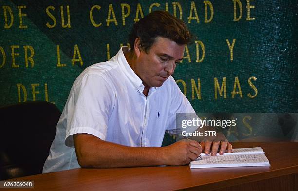 Antonio Castro Soto del Valle, Cuban revolutionary leader Fidel Castro's son, signs an oath of allegiance to his father's revolution concept at...