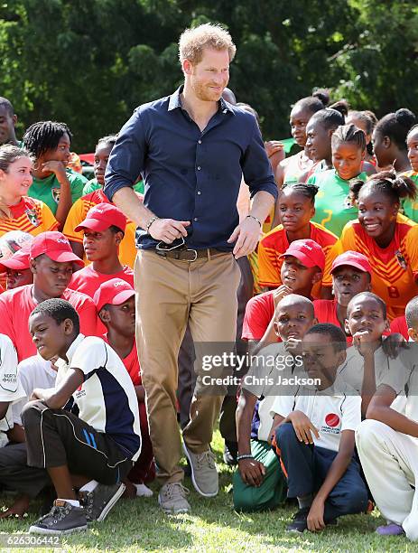 Prince Harry plays cricket as he attends a community sporting event at Queen Park Ground on the ninth day of an official visit to the Caribbean on...