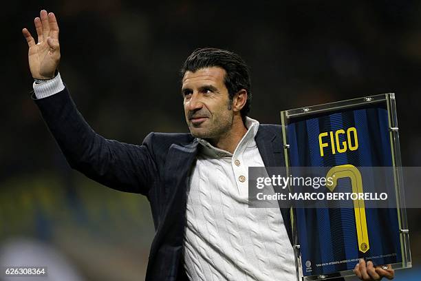 Former Inter Milan's player Luis Figo waves as he holds his jersey prior to the Italian Serie A football match between Inter Milan and Fiorentina on...