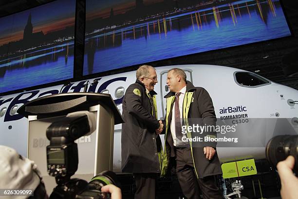 Robert Dewar, vice president and general manager of CSeries at Bombardier Inc., left, and Martin Gauss, chief executive officer of airBaltic, shake...