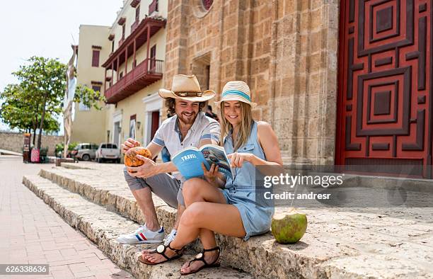 tourists looking at a travel guide - cartagena de indias stock pictures, royalty-free photos & images