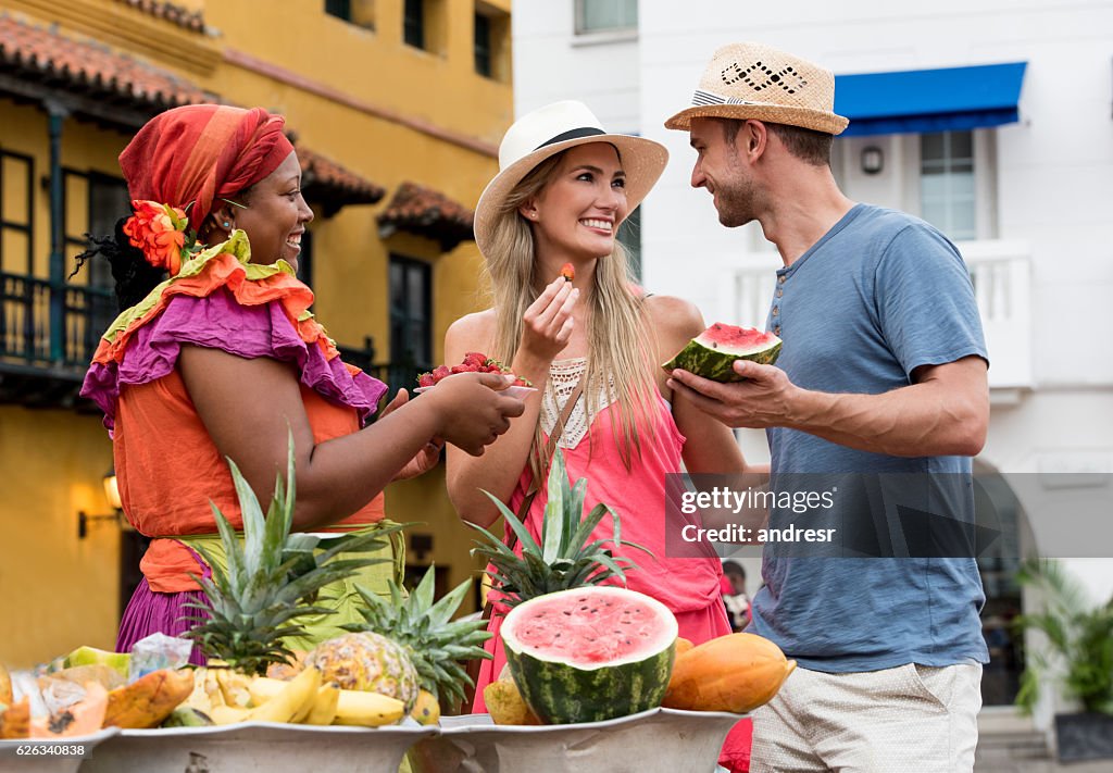 Couple of tourist buying fruits in the street
