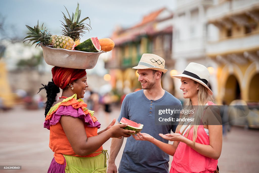 Pareja de turistas comprando frutas en la calle