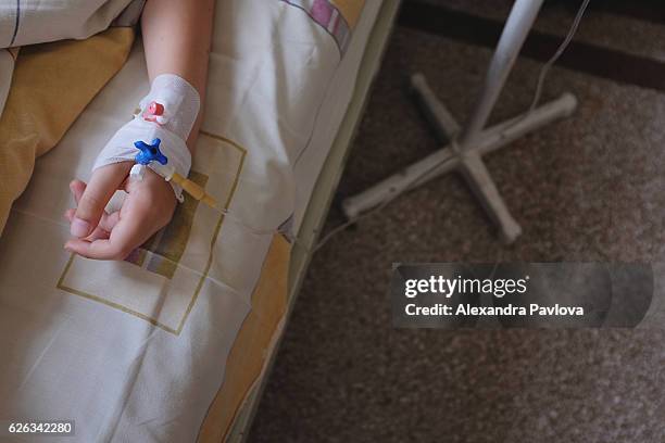 child's hand with iv drip attached - hospital bed with iv stock pictures, royalty-free photos & images