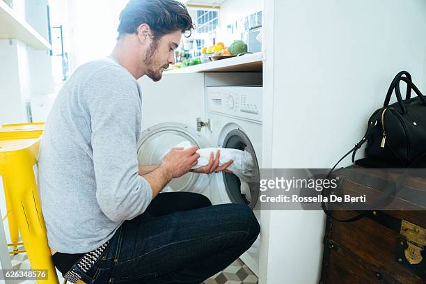 man at home doing laundry - stereotypical stock pictures, royalty-free photos & images