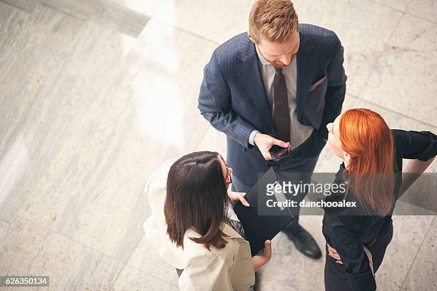 business people in the lobby talking overhead shot - medium group of people stock pictures, royalty-free photos & images