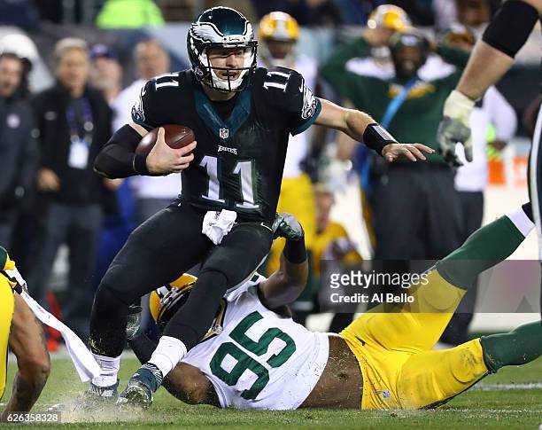 Carson Wentz of the Philadelphia Eagles scrambles and is tackled by Datone Jones of the Green Bay Packers in the fourth quarter at Lincoln Financial...