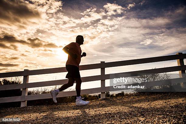 attraktive senior man jogging - steil haar stock-fotos und bilder