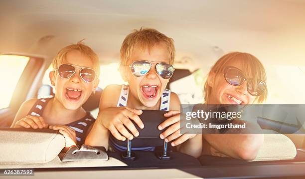 kinder spaß haben im auto auf einem ausflug - screaming happy in car stock-fotos und bilder