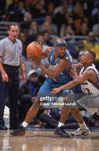 Point guard Baron Davis of the Charlotte Hornets holds the ball away from guard Chris Whitney of the Washington Wizards during the NBA game at the...
