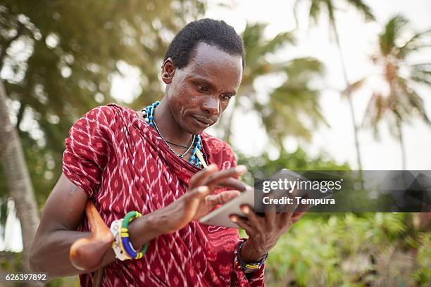 maasai nomadenmann mit technologie - africa community stock-fotos und bilder